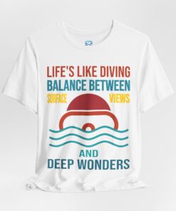 White diving t-shirt with a split-view design of a diver’s mask, featuring the phrase 'Life's Like Diving – Balance Between Surface Views and Deep Wonders' in bold typography with ocean-inspired colors