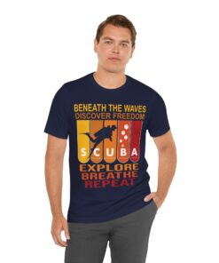 A male model wearing a navy blue scuba diving t-shirt featuring a bold, retro-style design. The shirt showcases a silhouette of a diver against a gradient background transitioning from yellow to deep red, with the words 