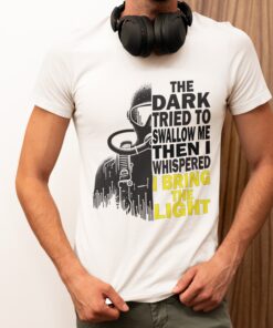 The Dark Diving T-Shirt featuring a diver’s silhouette in shadows and light, with the empowering quote 'The dark tried to swallow me, then I whispered I bring the light,' perfect for brave explorers and diving enthusiasts