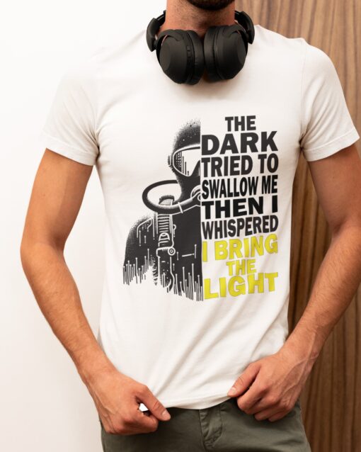 The Dark Diving T-Shirt featuring a diver’s silhouette in shadows and light, with the empowering quote 'The dark tried to swallow me, then I whispered I bring the light,' perfect for brave explorers and diving enthusiasts