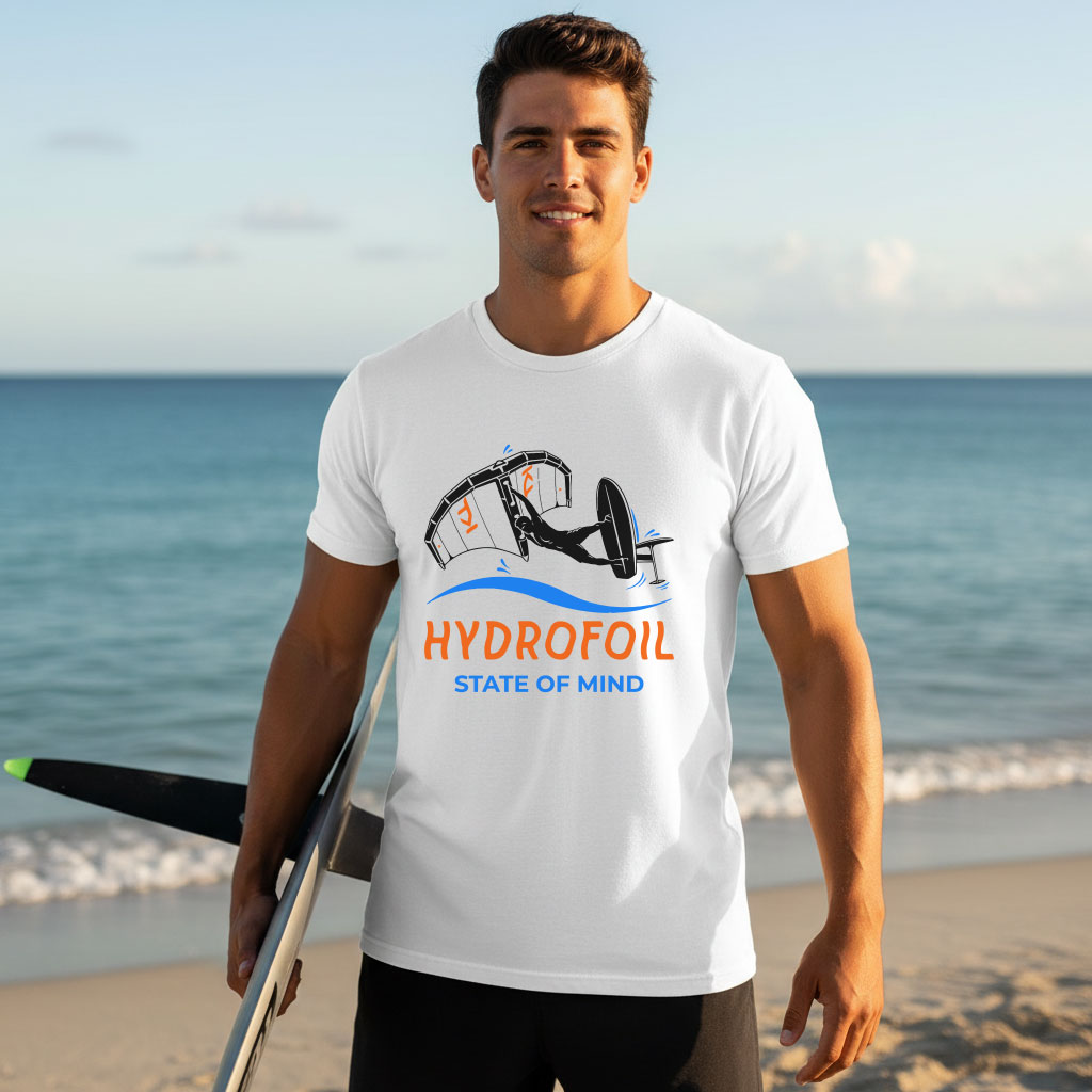 Man on a sunny beach wearing a white Hydrofoil T-Shirt featuring a wing foiling graphic print