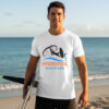 Man holding a hydrofoil board on a sunny beach wearing a white premium hydrofoil graphic t-shirt