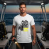 A young man standing on the deck of a dive boat at sunset holding a flashlight, wearing a white premium **night diving shirt** with a split scuba diver graphic and bold safety yellow typography