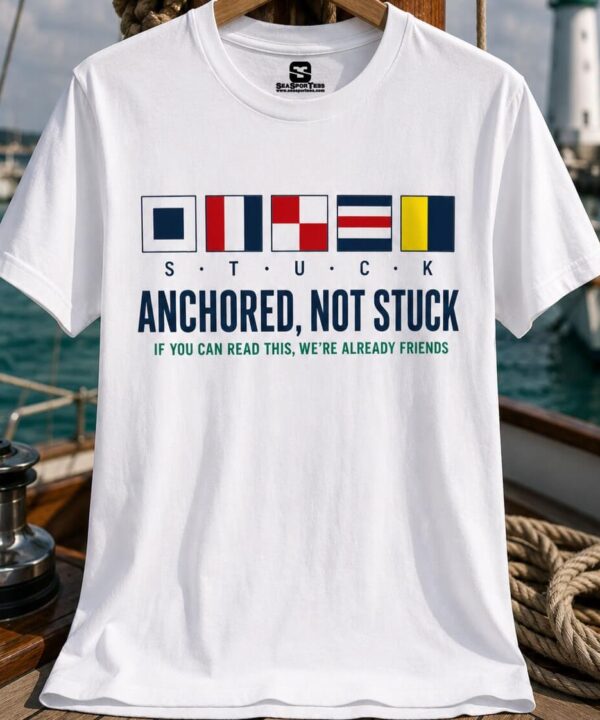 White unisex sailing tee with nautical signal flags spelling STUCK and Anchored Not Stuck sailor humor graphic
