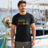 Man wearing black Reel Life Fishing Shirt with reel and lure graphic at marina dock, Seasportees fishing tee