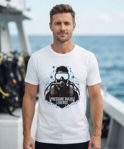 White scuba diving t-shirt featuring bold diver portrait with mask, regulator and BCD illustration, Pressure Builds Legends text, worn on dive boat